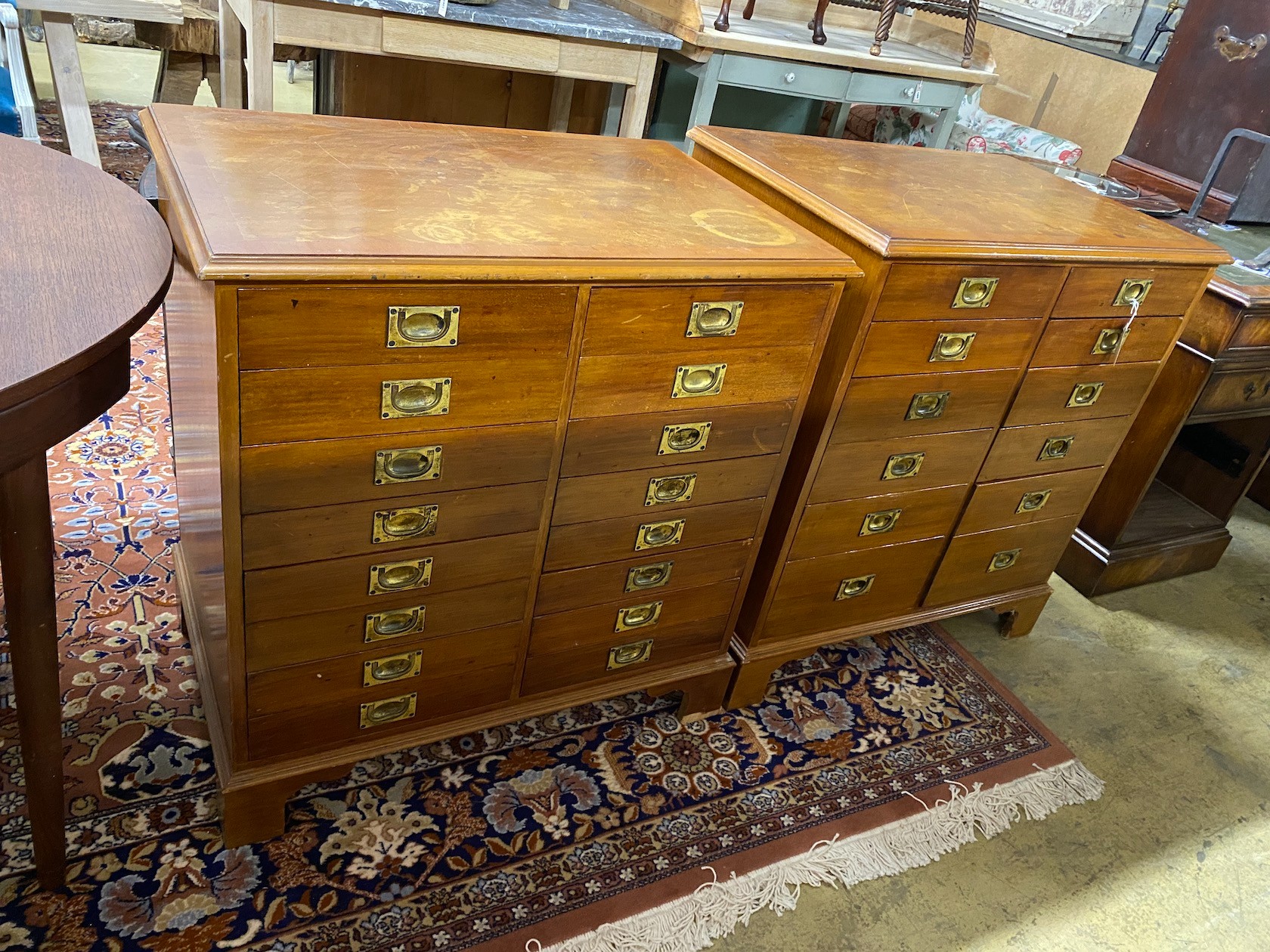 A near pair of mahogany and walnut military style chests of drawers, larger width 82cm, depth 54cm, height 85cm